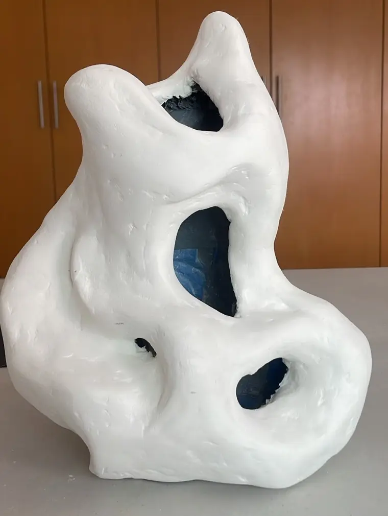 Modelo terminado en blanco, superficie lisa, interior azul visible por las aberturas.