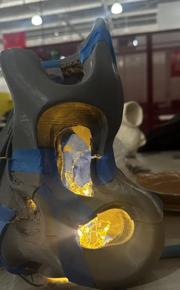 Impresión 3D gris de la lámpara con luces cálidas encendidas adentro.
